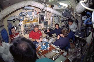 STS-91 and Mir-25 crewmembers share a meal in the Mir Space Station Base Block.